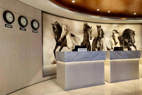 a group of horses on a display in a room with clocks at Courtyard by Marriott Riyadh Olaya in Riyadh