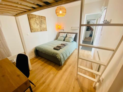 une petite chambre avec un lit et une table dans l'établissement Le petit Desbiey, à Arcachon