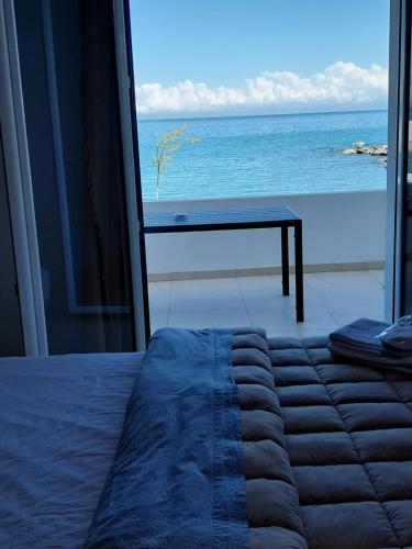 a bedroom with a bed and a view of the ocean at Galazio Seaside Luxury Rooms & Coffee Shop in Platamonas