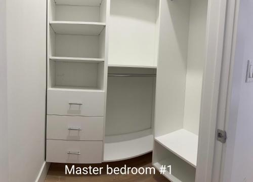 a walk in closet with white cabinets and drawers at Modern, New 3 bed, 2 bath Apt near Manhattan in Jersey City