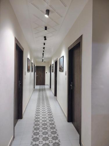 a hallway with doors and a tile floor in a building at Puri Inn in Varanasi