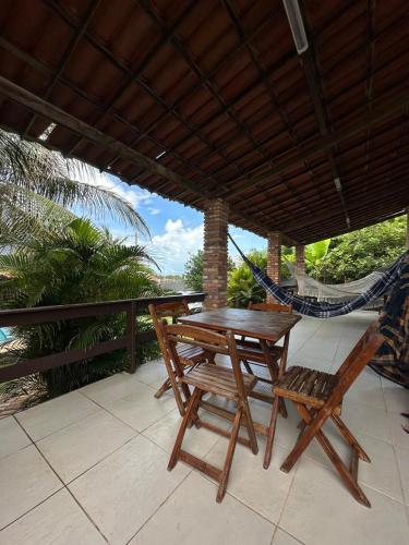 a porch with a hammock and a table and chairs at Casa Florida in Beberibe