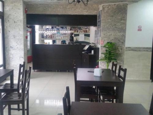 a restaurant with a table and chairs and a bar at Pensiune Matrix in Curtea de Argeş