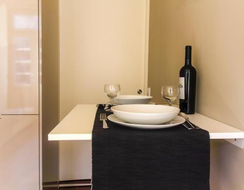 BmyGuest - Cardosas Stylish Apartment في بورتو: طاولة عليها صحن واكواب للنبيذ