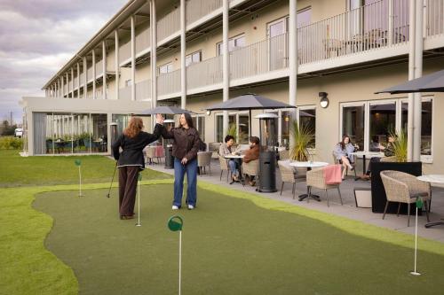 dos personas están jugando golf en un putting green en The Club Hotel at Goffs, en Naas