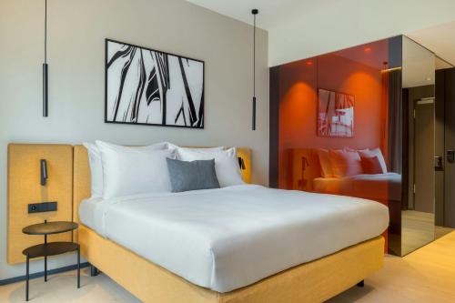 a bedroom with a large white bed and a chair at DAS AFFALTERBACH, Stuttgart, Autograph Collection in Affalterbach