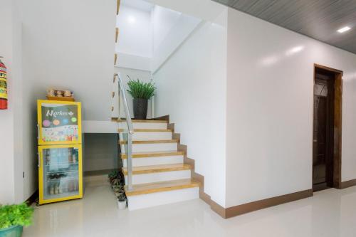 a staircase in a room with white walls and a stair case at Loboc Riverside Inn & Restaurant in Loboc