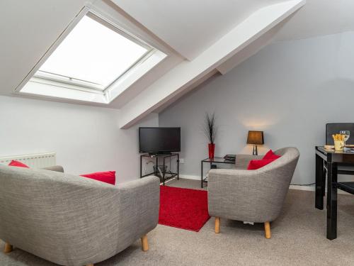 a living room with two chairs and a television at Porto Seguro in Brixham