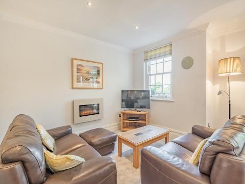 ein Wohnzimmer mit Sofa und Fernseher in der Unterkunft Apartment 14, Hazelwood Hall in Silverdale