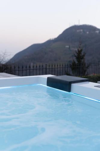 a blue swimming pool with a mountain in the background at Ca' Baetti l'Antica Corte in Roncola