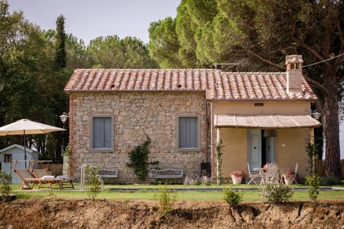 a small stone house with a table and an umbrella at Villa Il Nido in Cortona