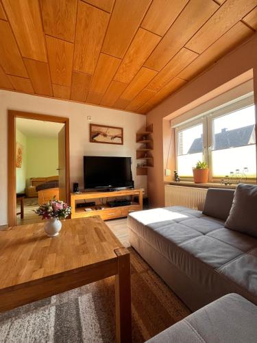 a living room with a couch and a flat screen tv at Ferienwohnung Gartenglück bei Eckernförde in Kochendorf