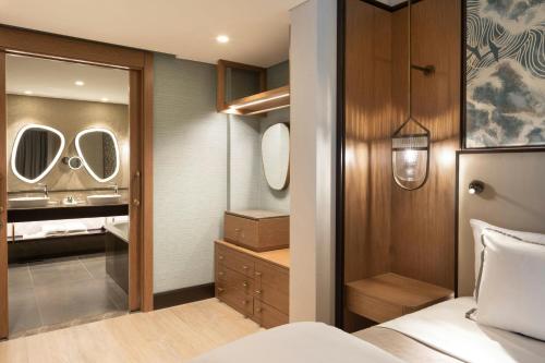 a bedroom with a bed and a bathroom with a mirror at The Westin Istanbul Nisantasi in Istanbul