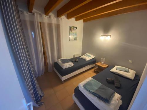 une petite chambre avec deux lits et une table dans l'établissement Au pied de la dune, agréable maison T5 et jardin, à Moliets-et-Maa