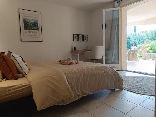 une chambre avec un lit et une porte coulissante en verre dans l'établissement Le Jas des Cayrons, à Vence