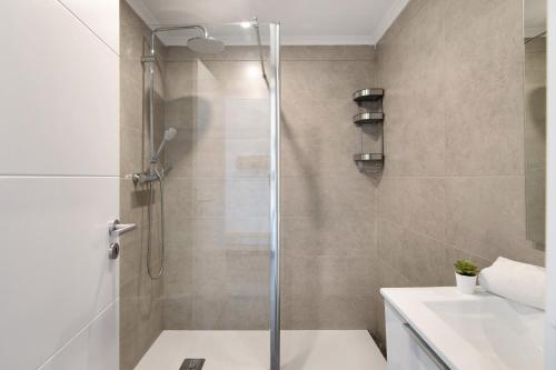 eine Dusche mit Glastür im Badezimmer in der Unterkunft Magnificent Beach Apartment in Vale de Pedras