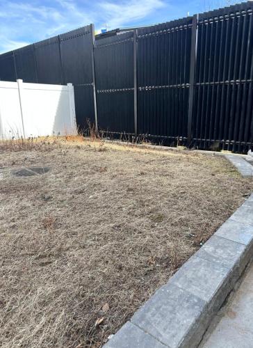 a fence in front of a yard with dirt at Modern, New 3 bed, 2 bath Apt near Manhattan in Jersey City