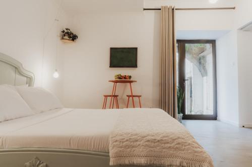 a bedroom with a white bed and a window at Casa da Peça Lodge in Ponta Delgada
