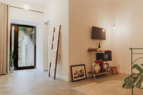 a living room with a door and a tv at Casa da Peça Lodge in Ponta Delgada