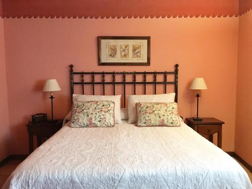 a bedroom with a large bed with two lamps at Hotel la Casa del Abuelo in Albarracín