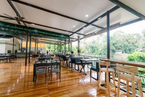 a restaurant with wooden floors and tables and chairs at Loboc Riverside Inn & Restaurant in Loboc