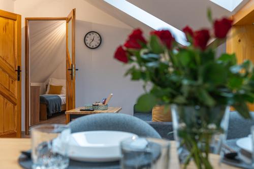 a table with a vase of red roses on a table at Apartamenty Wisła Krzywa 8, wanna z hydromasażem, basen zewnętrzny in Wisła