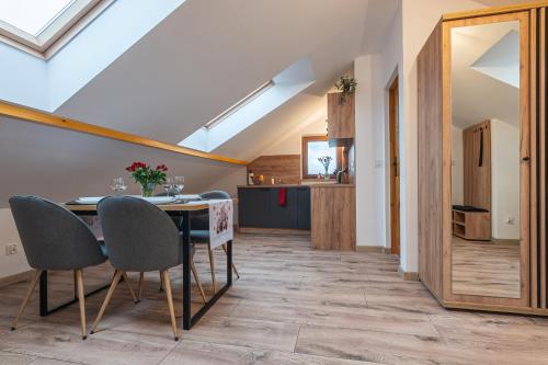 a kitchen and dining room with a table and chairs at Apartamenty Wisła Krzywa 8, wanna z hydromasażem, basen zewnętrzny in Wisła
