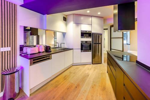 d'une cuisine avec des placards blancs et des plafonds violets. dans l'établissement Le Saint-Maurice Wifi Centre-ville, à Angers