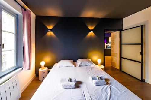 une chambre avec un grand lit avec deux serviettes dessus dans l'établissement Le Saint-Maurice Wifi Centre-ville, à Angers