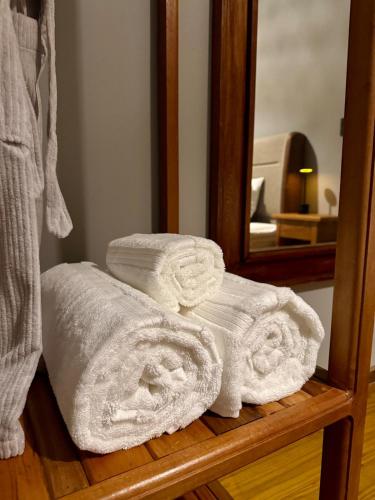 a pile of towels on a wooden shelf in front of a mirror at Villaggio Torrelaguna Cabana Roma in Cunha