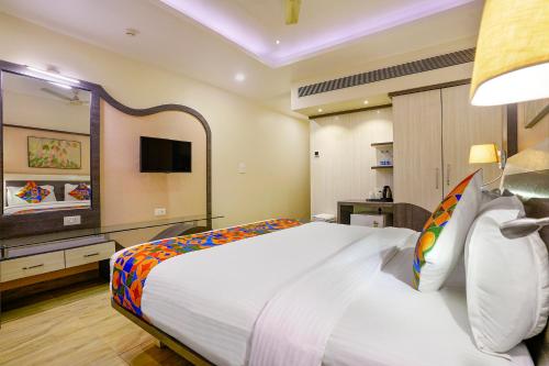 a hotel room with a large bed and a television at FabHotel Prestige Nr Maapusa Bus Stop in Guirim