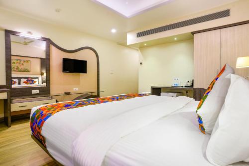 a bedroom with a large white bed and a television at FabHotel Prestige Nr Maapusa Bus Stop in Guirim