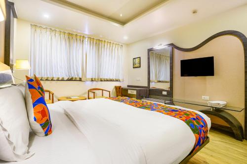 a hotel room with a large bed and a television at FabHotel Prestige Nr Maapusa Bus Stop in Guirim