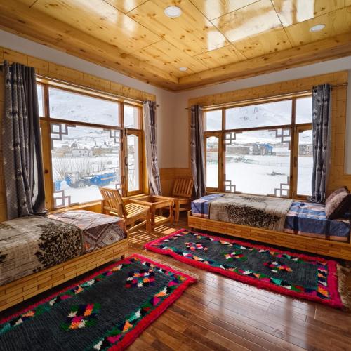 a bedroom with two beds and a table at Padum Eco Residence in Padam