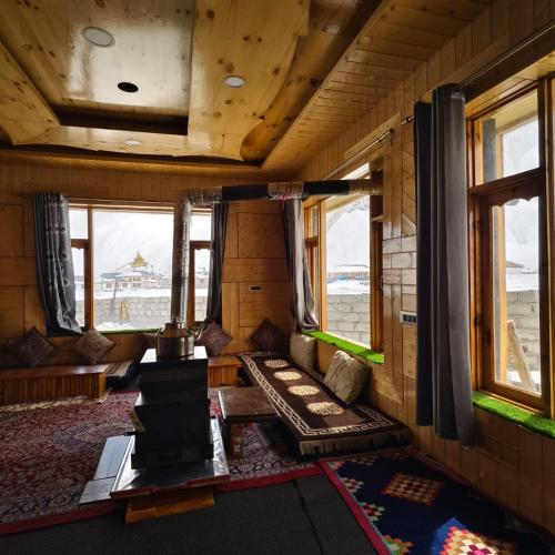 a living room with a couch and a table and windows at Padum Eco Residence in Padam
