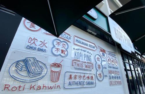 a sign on the side of a building with signs on it at K avenue B3A 2bed studio room in Donggongon