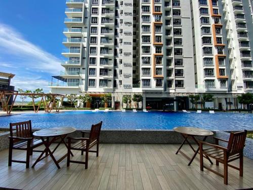 a hotel with tables and chairs next to a swimming pool at K avenue B3A 2bed studio room in Donggongon