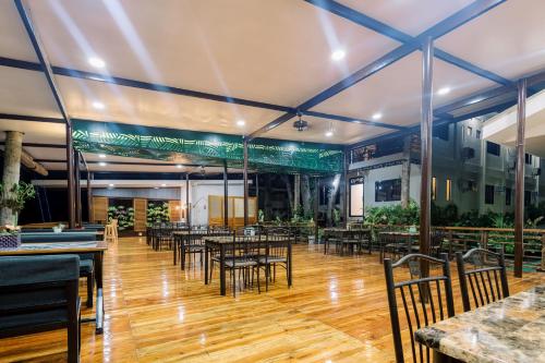 a restaurant with tables and chairs in a room at Loboc Riverside Inn & Restaurant in Loboc