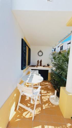 a patio with a table and two white chairs at Albufeira Home Paderne in Paderne