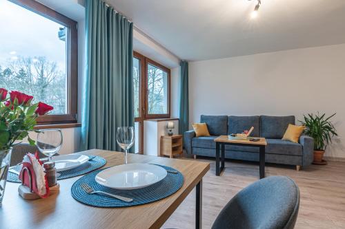 a living room with a table and a couch at Apartamenty Wisła Krzywa 8, wanna z hydromasażem, basen zewnętrzny in Wisła