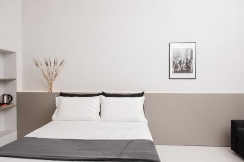 a bed in a room with a white wall at Iodis Relais in Naples