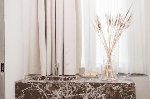 a marble table with a vase and flowers on it at Iodis Relais in Naples