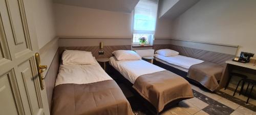 a room with three beds and a window at Pokoje Gościnne Gum-Bar in Biskupice