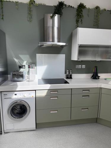 a kitchen with a washing machine and a washer at Courtyard Mews - 2 large en suite bedrooms, Garden - Harrogate Holiday Apartments in Harrogate