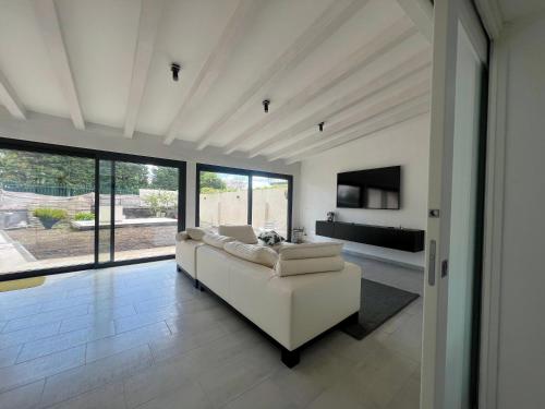 a living room with a white couch and a tv at Villa Leonessa in Tremestieri Etneo