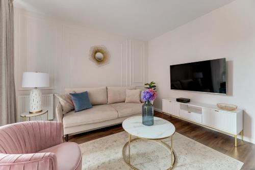 a living room with a couch and a tv at Scala City Center Magic Apartments with Parking by Lion Apartments in Gdańsk