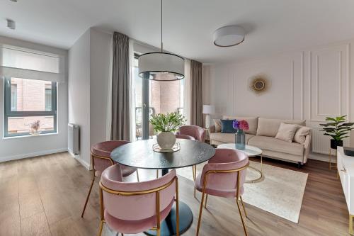 a living room with a table and chairs at Scala City Center Magic Apartments with Parking by Lion Apartments in Gdańsk
