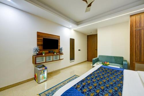 a hotel room with a bed and a chair and a tv at Hotel Dream World - Free Airport Drop in New Delhi