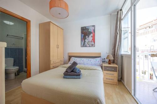 een slaapkamer met een groot bed en een badkamer bij Complejo Andalucía Torrecilla Beach in Nerja