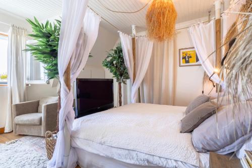 a bedroom with a canopy bed and a chair at Villa avec vue sur mer imprenable in Loctudy